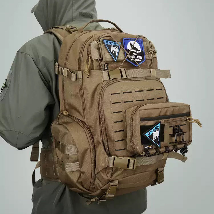 Man carrying a coyote brown tactical backpack with laser-cut MOLLE panels and morale patches